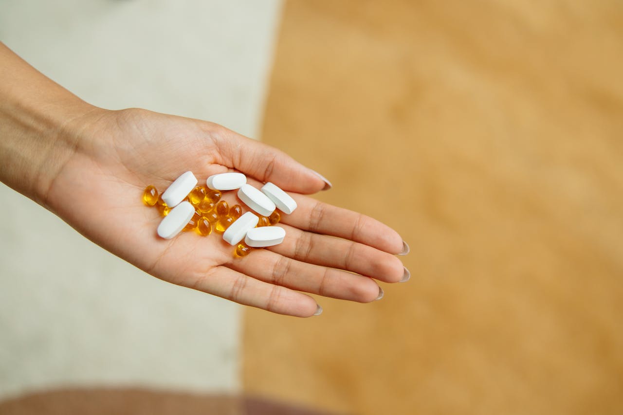Mastering the First Impression: Your intriguing post title goes here Close-up of a hand holding white pills and yellow capsules, symbolizing health and wellness.